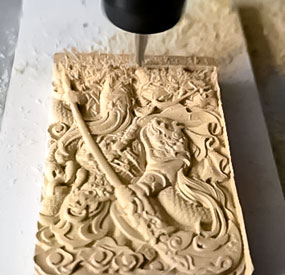 X3M desktop CNC machine carving hardwood relief with detailed oak grain